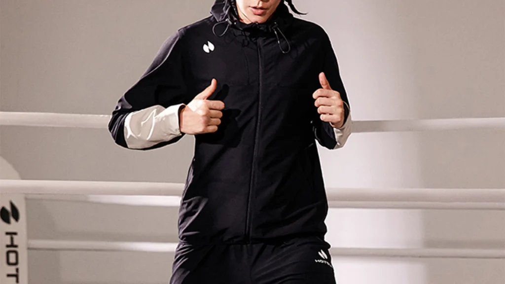 woman wearing black sauna suit jogging treadmill sweating