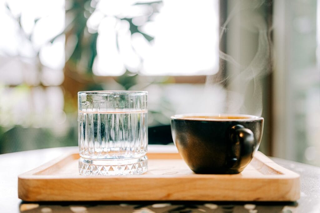 water glass next to cup of tea morning