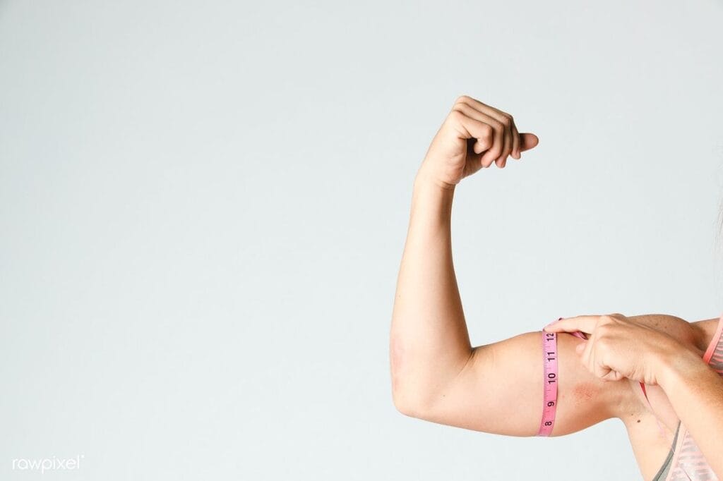 woman measuring bicep with tape measure